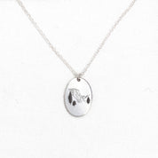 a voyager charm necklace with a mountain engraving
