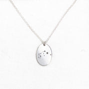 a voyager charm necklace with a zodiac constellation engraving