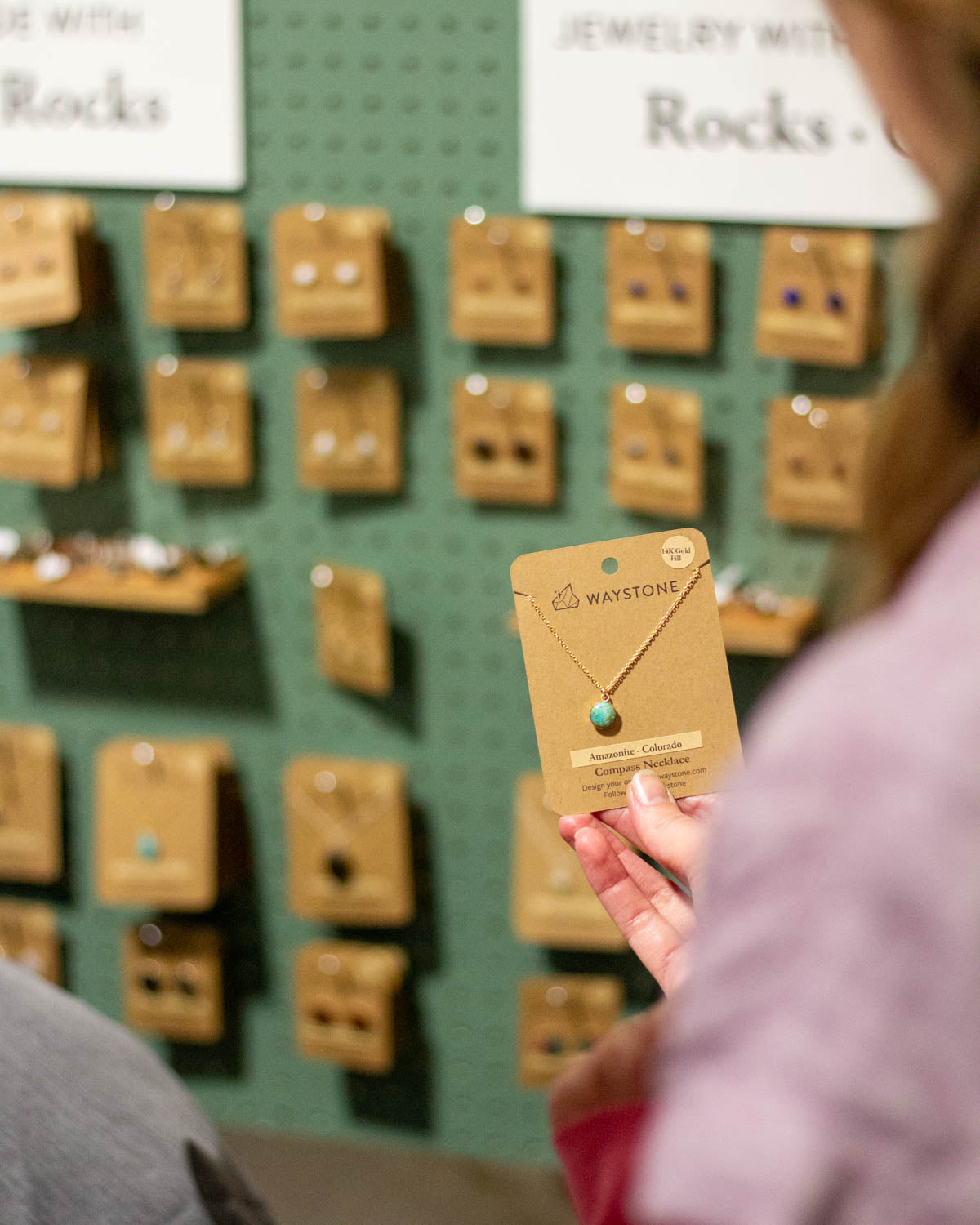 Leslie holding a necklace made from Amazonite in the Waystone market booth 