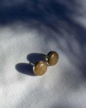 Pair of green stone stud earrings with a sterling silver setting