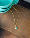 Blue-green Amazonite stone set as a small round pendant necklace on a gold chain