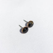 Pair of black stone stud earrings with a 14k gold fill setting on a white background