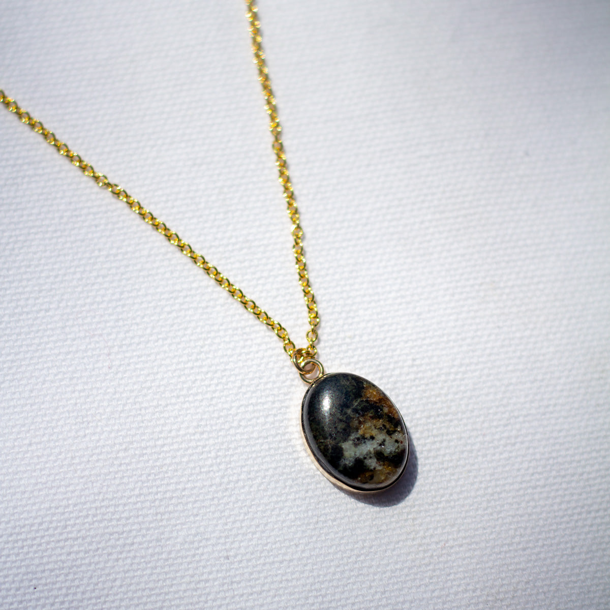 A stone pendant necklace made with natural granite and 14k gold fill