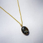 A stone pendant necklace made with natural granite and 14k gold fill