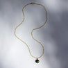 14k gold necklace with a delicate chain and a charm made out of a natural stone