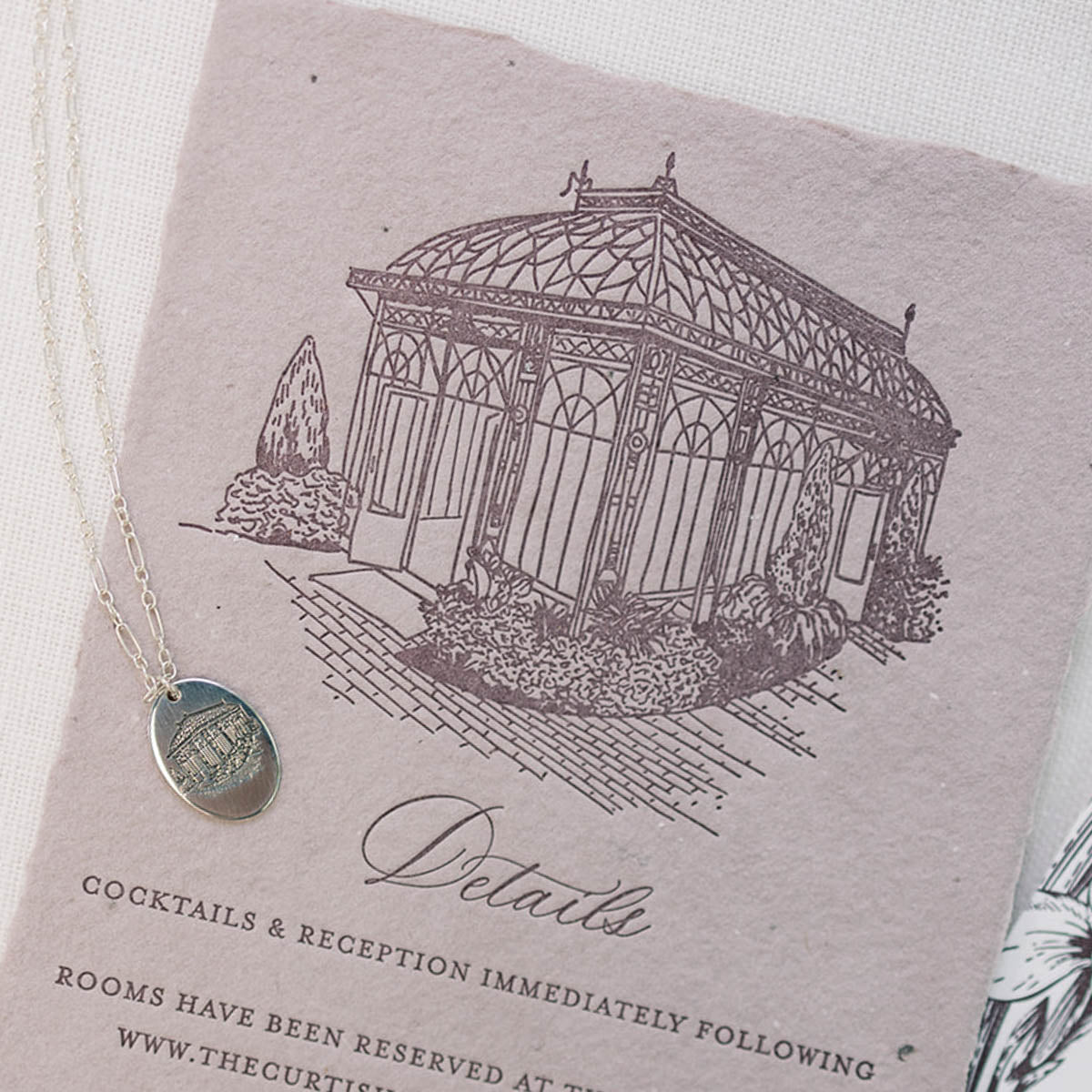 An illustrated wedding invitation with a matching engraved sterling silver charm necklace