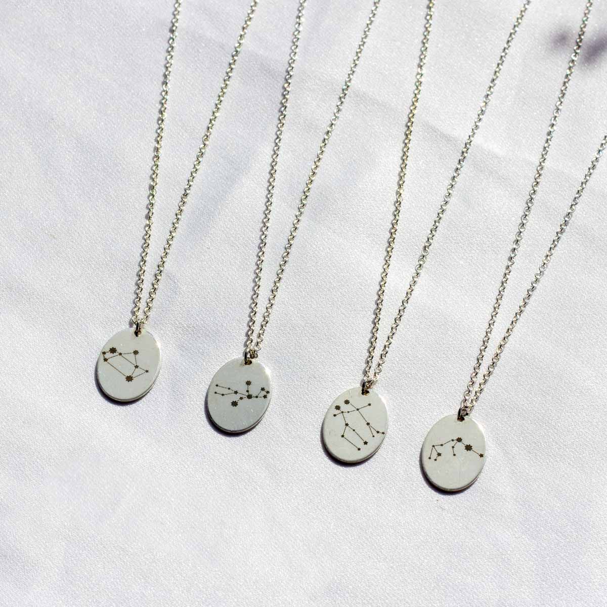 four voyager charm necklaces with zodiac constellations.  Sagittarius,  Virgo, Gemini, and Aquarius charms pictured