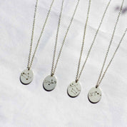 four voyager charm necklaces with zodiac constellations.  Sagittarius,  Virgo, Gemini, and Aquarius charms pictured