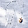 A long sterling silver chain with a brown speckled stone pendant