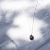 A long/short sterling silver chain with a small raw stone pendant set in sterling silver