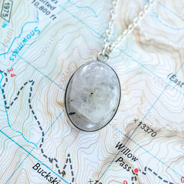 A white natural stone pendant sits on a map of Willow Pass