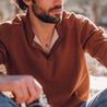 Man wears a choker with a small green oval pendant made of natural stone